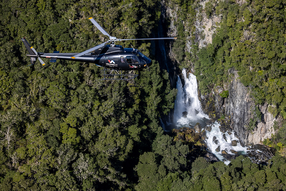 helicopter flying over a waterfall