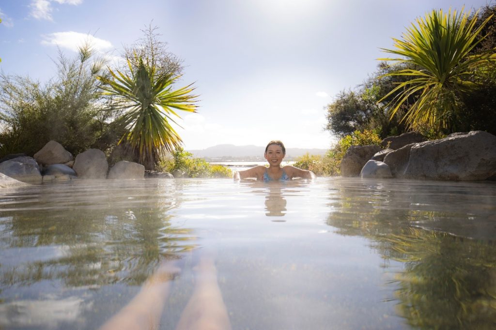 Person sitting in hot spring spa in Rotorua