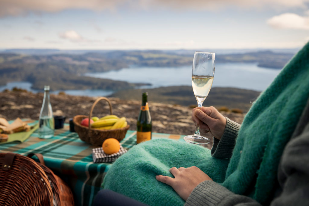 A woman drinking wine on a mountain