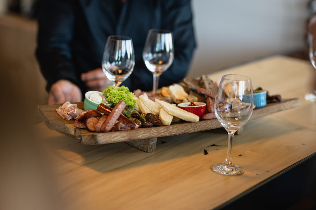 A winery with a platter and three glasses of wine