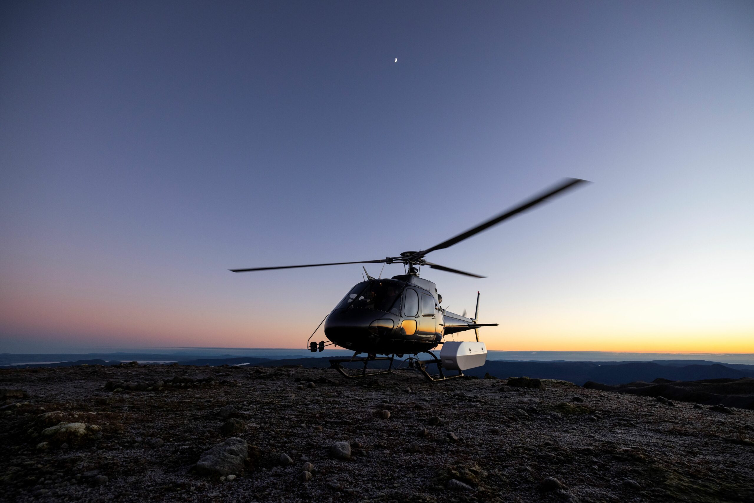 Helicopter landing on Mt Tarawera at sunrise