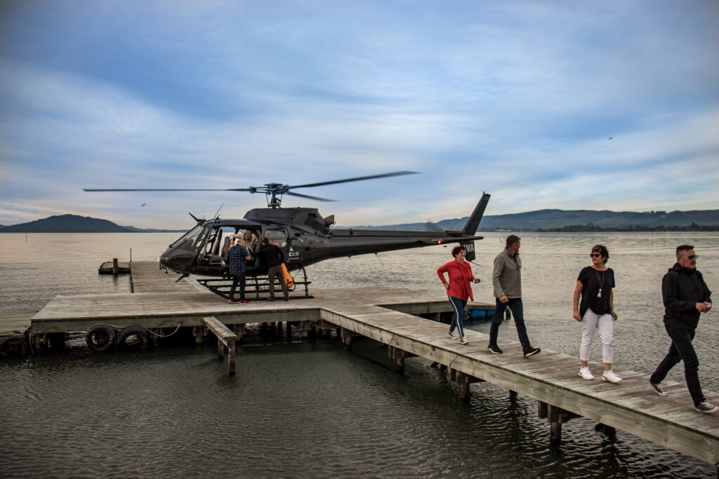 Passengers disembarking helicopter at lakefront